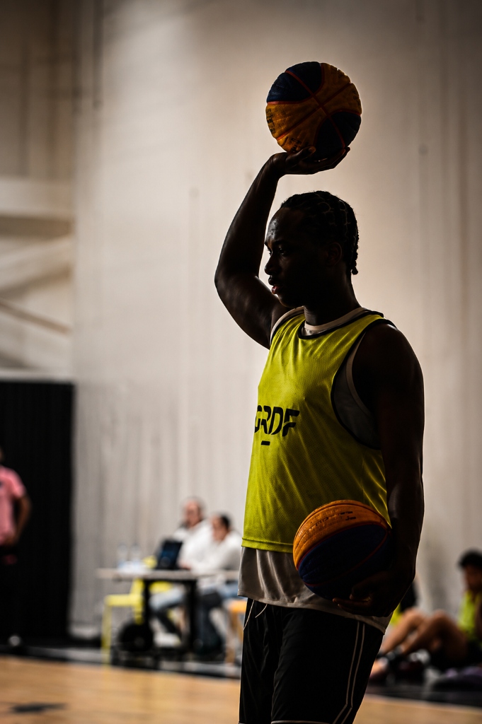 Joueur de basket 3x3 posant avec le ballon de streetball